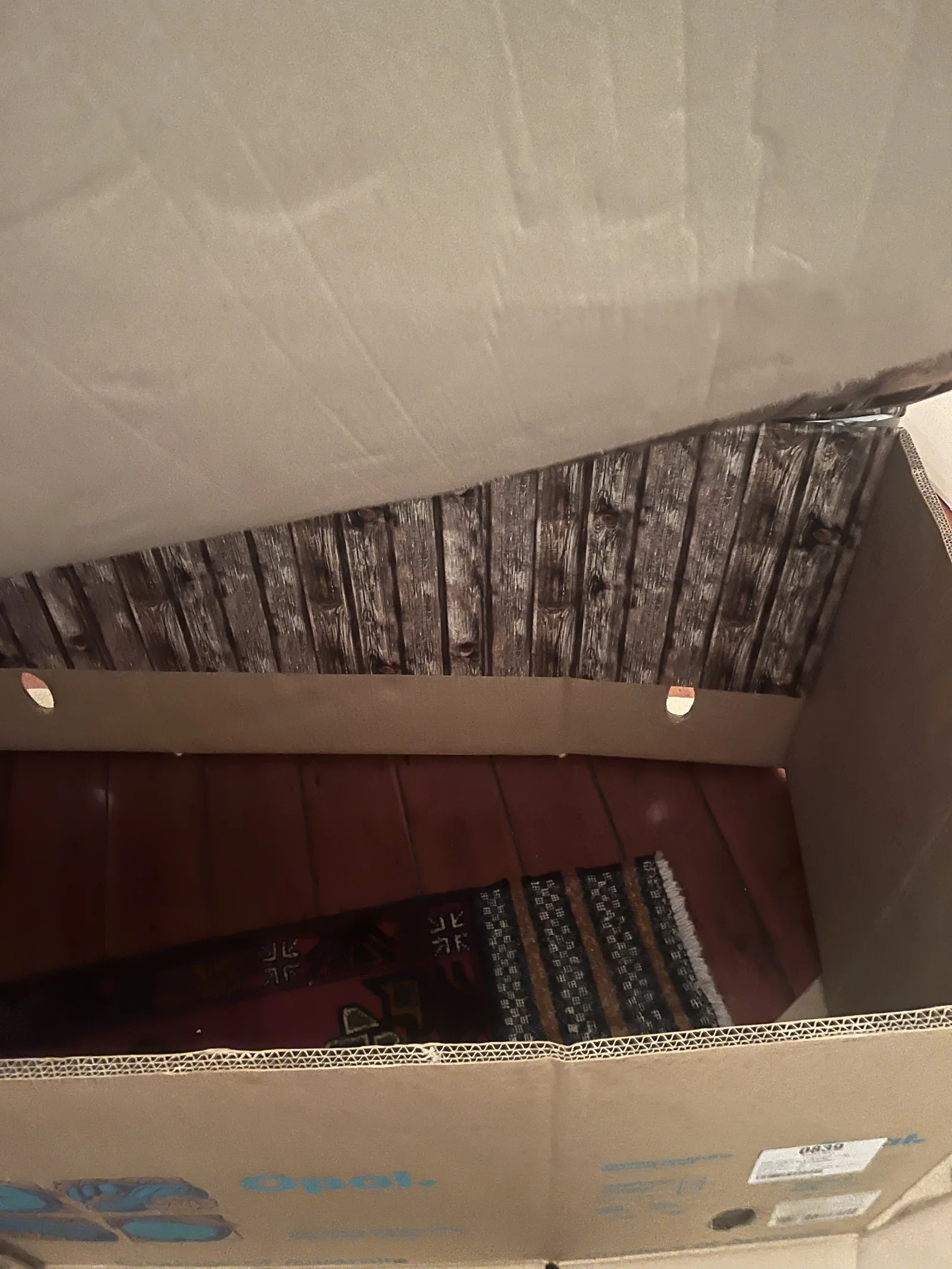 O interior da caixa de papelão revestido com papel que imita madeira