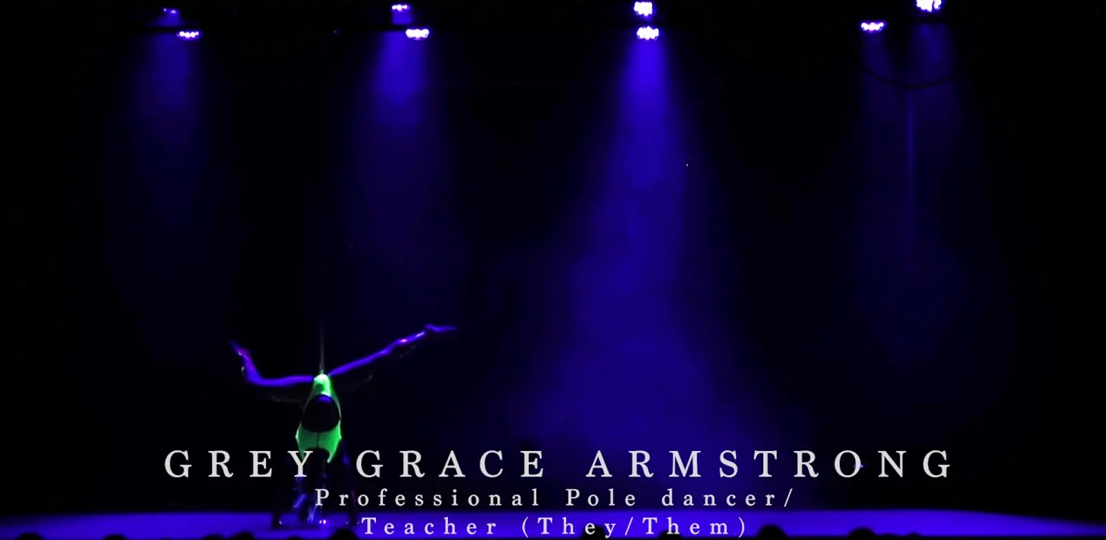 A pole dancer performing on a dark stage under blue light, with the caption Grey Grace Armstrong, professional pole dancer and teacher