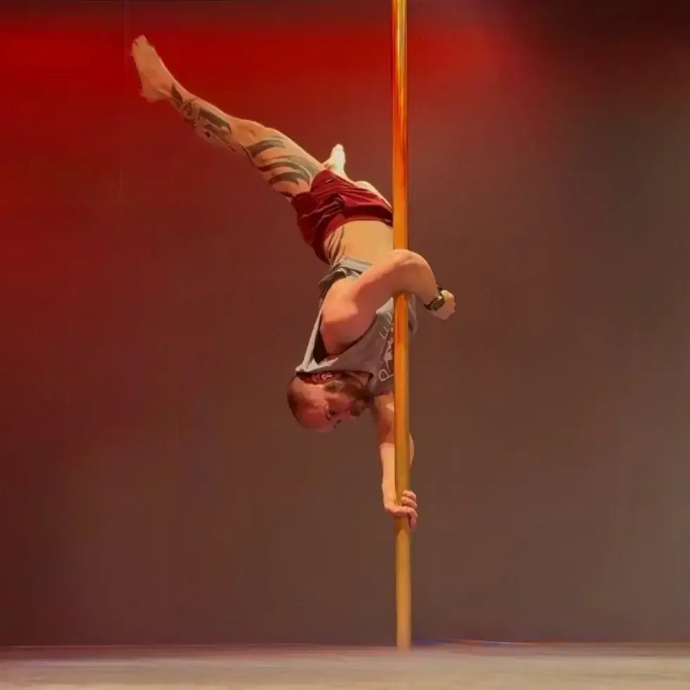 Una persona sosteniendo una pose en el pole