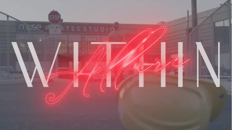 O título Allure Within em letras de neon vermelho sobre uma rua cinza